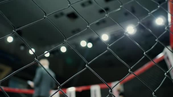 Octagon before fight, mixed martial arts tournament in cage, grid in foreground. — Stock Video