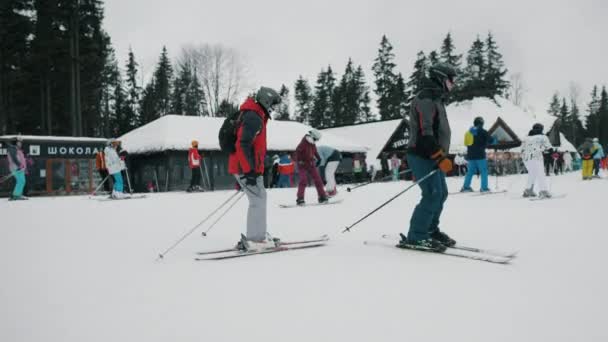 ブコヴェル、ウクライナ、 2021年2月:スキーリゾートで下り坂に行くスキーヤー、冬の山の中で活発な休息 — ストック動画
