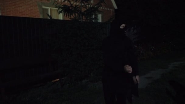 Een dief in een masker draagt 's avonds laat een gestolen tv, wordt betrapt door de politie met zwaailichten, rent weg, concept van veiligheid — Stockvideo