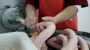 Bir et fabrikasında sosis üretim süreci. İşçiler sosisi şekillendiriyor..