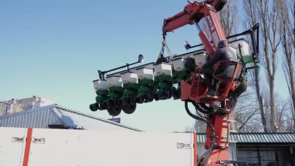 Manipulateur charge un semoir agricole sur un wagon — Video