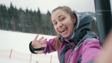 Mutlu kız dağlarda kayak merkezinde ailesine video görüşmeleri yapıyor, kış dağlarında selfie çekiyor.