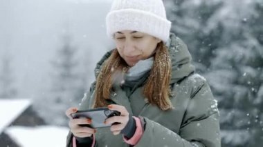 Genç ve güzel bir kadın duygusal olarak oyun oynar, kazanır ve sevinir. Kışın kar altında cep telefonu kullan