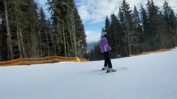 Лыжники спускаются на горнолыжном курорте, активный отдых в зимних горах — стоковое видео