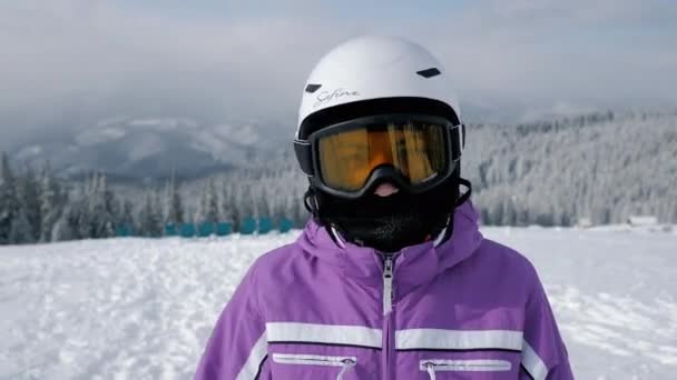 カルパティア,ウクライナ- 2021年2月:山の上に、スキー用保護ゴーグルのカメラを見てスポーツ女性の肖像画 — ストック動画