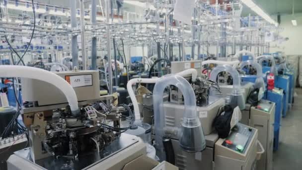 Processo de produção de meias de algodão na fábrica de vestuário, processo automatizado, muitas máquinas sem pessoas. — Vídeo de Stock