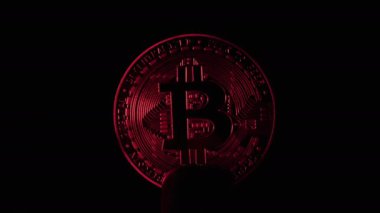 Bitcoin para siyah arkaplanda ışık ile aydınlatılmış.
