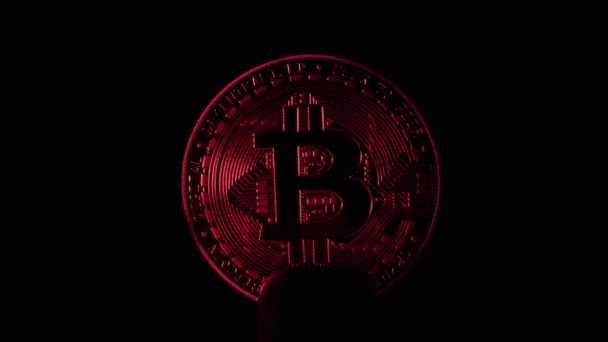 Bitcoin iluminado con luz sobre fondo negro. — Vídeos de Stock