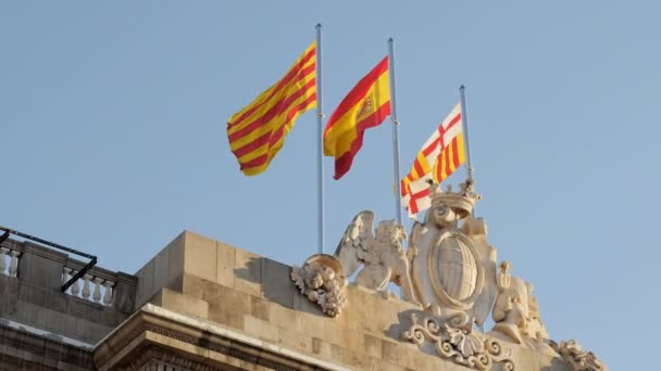 Flags of Spain and Catalonia on the roof of the historic city hall in the square. — Stock Video