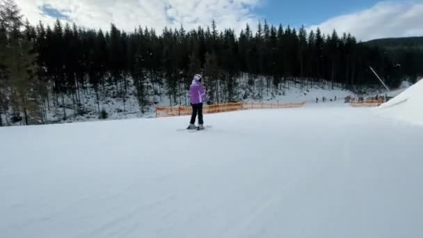 Esquiadores descendo em uma estância de esqui, descanso ativo em montanhas de inverno — Vídeo de Stock