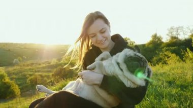 Kadın köpeğine sarılıyor ve tırmalıyor. Komik yorgun köpek, sahibinin ellerinde rahatla, hayvanları sev.