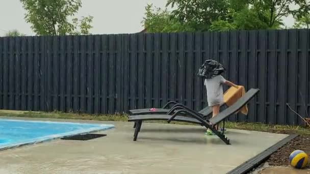 Funny boy put a bag on his head to shelter from the rain — Vídeo de Stock