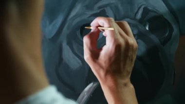Ressam, tuvale zarif bir köpek portresi çiziyor.