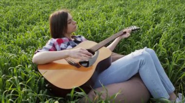 Kadın buğday tarlasında yatıyor gitarla müzik çalıyor ve gün batımında ağır çekimde şarkı söylüyor..