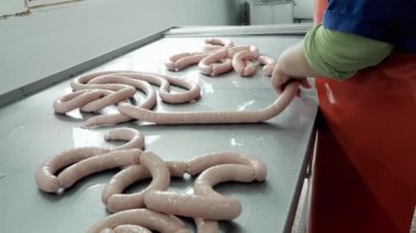 Bir et fabrikasında endüstriyel sosis üretimi. Tanınmayan işçiler sosisi şekillendiriyor.