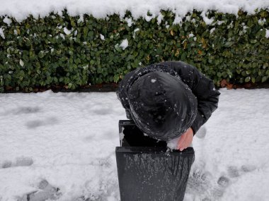 Çocuk soğuk kış mevsiminde buzlu su içer.