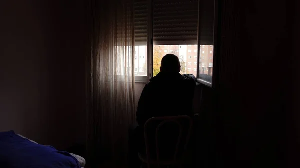 Muž Sedí Tmavé Místnosti Dívá Otevřeného Okna — Stock fotografie