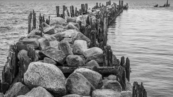 Old Pier Made Stones Wooden Legs Left Metal Screeds Water — Stock Photo, Image