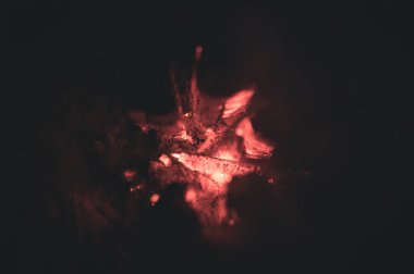 Ateşin alevlerinden çıkan duman ve tepedeki oyuklardan dikey olarak yanan tahta bir direk, böylece ateş odunları daha iyi yakar.