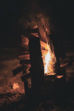 Ateşin alevlerinden çıkan duman ve tepedeki oyuklardan dikey olarak yanan tahta bir direk, böylece ateş odunları daha iyi yakar.