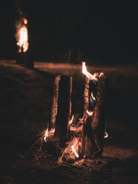 Ateşin alevlerinden çıkan duman ve tepedeki oyuklardan dikey olarak yanan tahta bir direk, böylece ateş odunları daha iyi yakar.