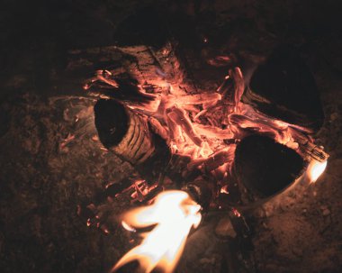 Ateşin alevlerinden çıkan duman ve tepedeki oyuklardan dikey olarak yanan tahta bir direk, böylece ateş odunları daha iyi yakar.