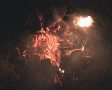 Ateşin alevlerinden çıkan duman ve tepedeki oyuklardan dikey olarak yanan tahta bir direk, böylece ateş odunları daha iyi yakar.