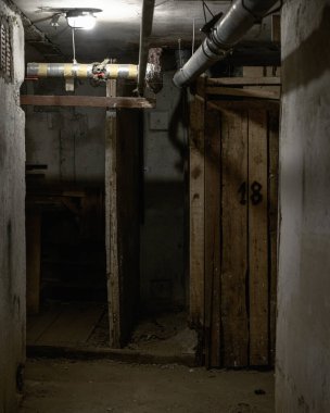 Dokuz katlı Sovyet döneminden kalma kapısı olmayan bir binanın bodrumunda elektrik ve kanalizasyonla terk edilmiş bir bodrum.