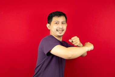 Asyalı bir adam mutlu ve dans ediyor. kırmızı arkaplan. 