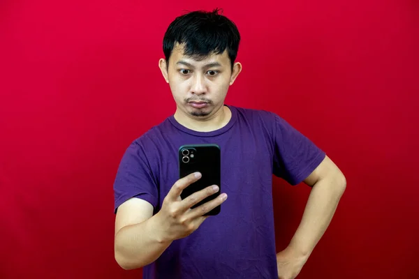 Asiatisk Man Klädd Lila Shirt Tittar Sin Smarta Telefon Med — Stockfoto