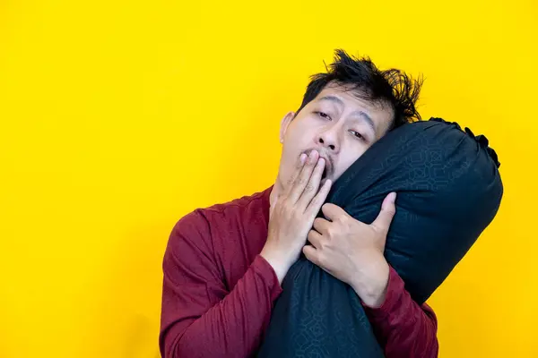 Cute Asian Man Hugging Bolster Sleepy Expression Waking Yellow Background — Stock Photo, Image
