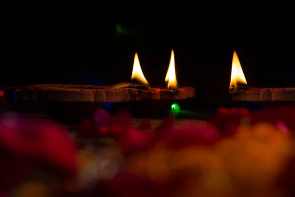 Diwali sırasında siyah arkaplan üzerine dekore edilmiş diyas grubu