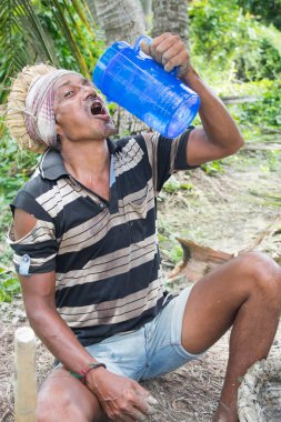 Köyde bir adam kafasında toprak dolu ağır bir sepet taşır.