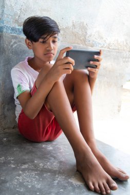 Akıllı telefonda tek başına oynayan bir çocuk.