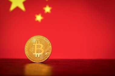 Arka planda Çin bayrağı olan altın madeni para
