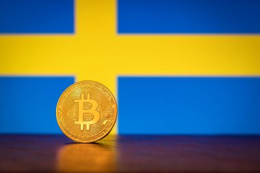 Arka planda İsveç bayrağı olan Altın Fiziksel Bitcoin