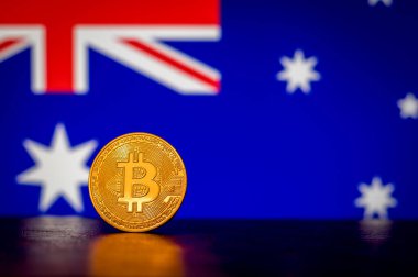 Arka planda Avustralya bayrağı olan altın fiziksel Bitcoin
