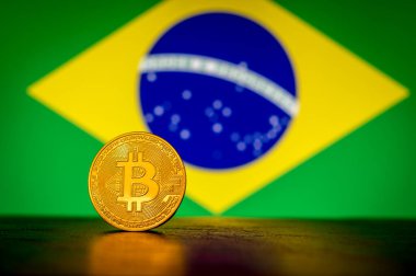 Arka planda Brezilya bayrağı olan altın fiziksel Bitcoin