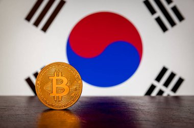 Arka planda Güney Kore bayrağı olan Altın Fiziksel Bitcoin