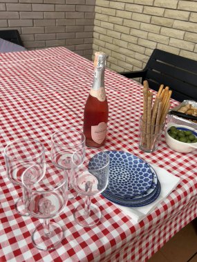 Autumn picnic on the terrace. Table setting with wine and snacks. The table on the terrace is covered with a checkered tablecloth. High quality photo