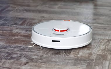 Robot elektrik süpürgesi ahşap zeminde otomatik temizlik yapıyor.