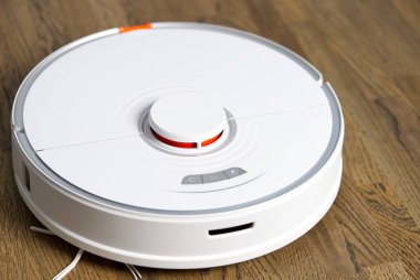 Robot elektrik süpürgesi ahşap zeminde otomatik temizlik yapıyor.