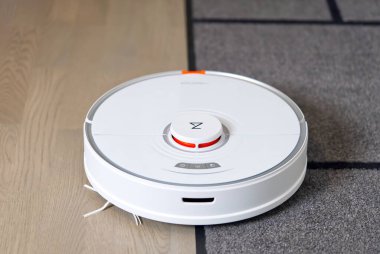 Tallinn, Estonya - 10 Ekim 2021: Xiomi s7 roborock elektrik süpürgesi daireyi halı ve katlarla otomatik olarak temizliyor