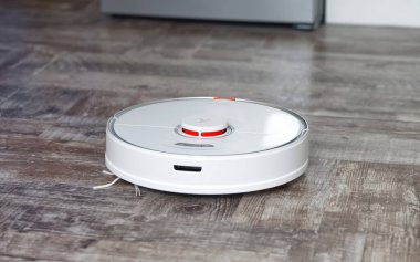 Tallinn, Estonya - 10 Ekim 2021: Xiomi s7 roborock elektrikli süpürge ahşap zeminde otomatik temizlik yapıyor