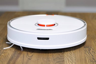 Robot elektrik süpürgesi ahşap zeminde otomatik temizlik yapıyor.