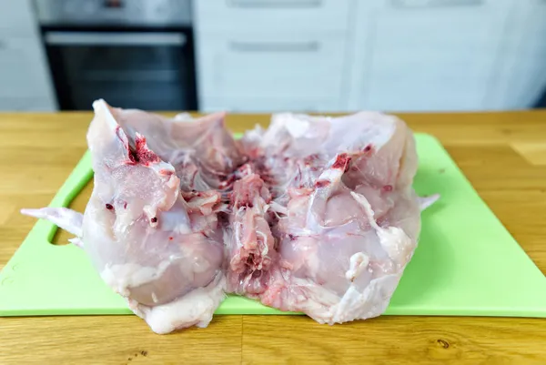 Raw chicken cutted in half on a cutting board. Home food making process. — Stock Photo, Image