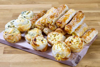 Turtalar ve çörekler ahşap bir masada. Taze hamur işleri evde hazırlanır. Lezzetli çıtır aperatifler..