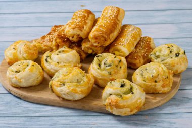 Turtalar ve çörekler ahşap bir masada. Taze hamur işleri evde hazırlanır. Lezzetli çıtır aperatifler..