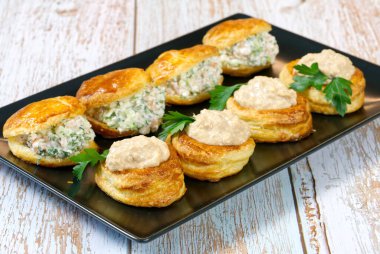 Bir tabakta salata ile doldurulmuş börek dolu aperatif.