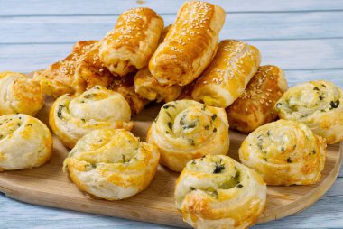 Turtalar ve çörekler ahşap bir masada. Taze hamur işleri evde hazırlanır. Lezzetli çıtır aperatifler..